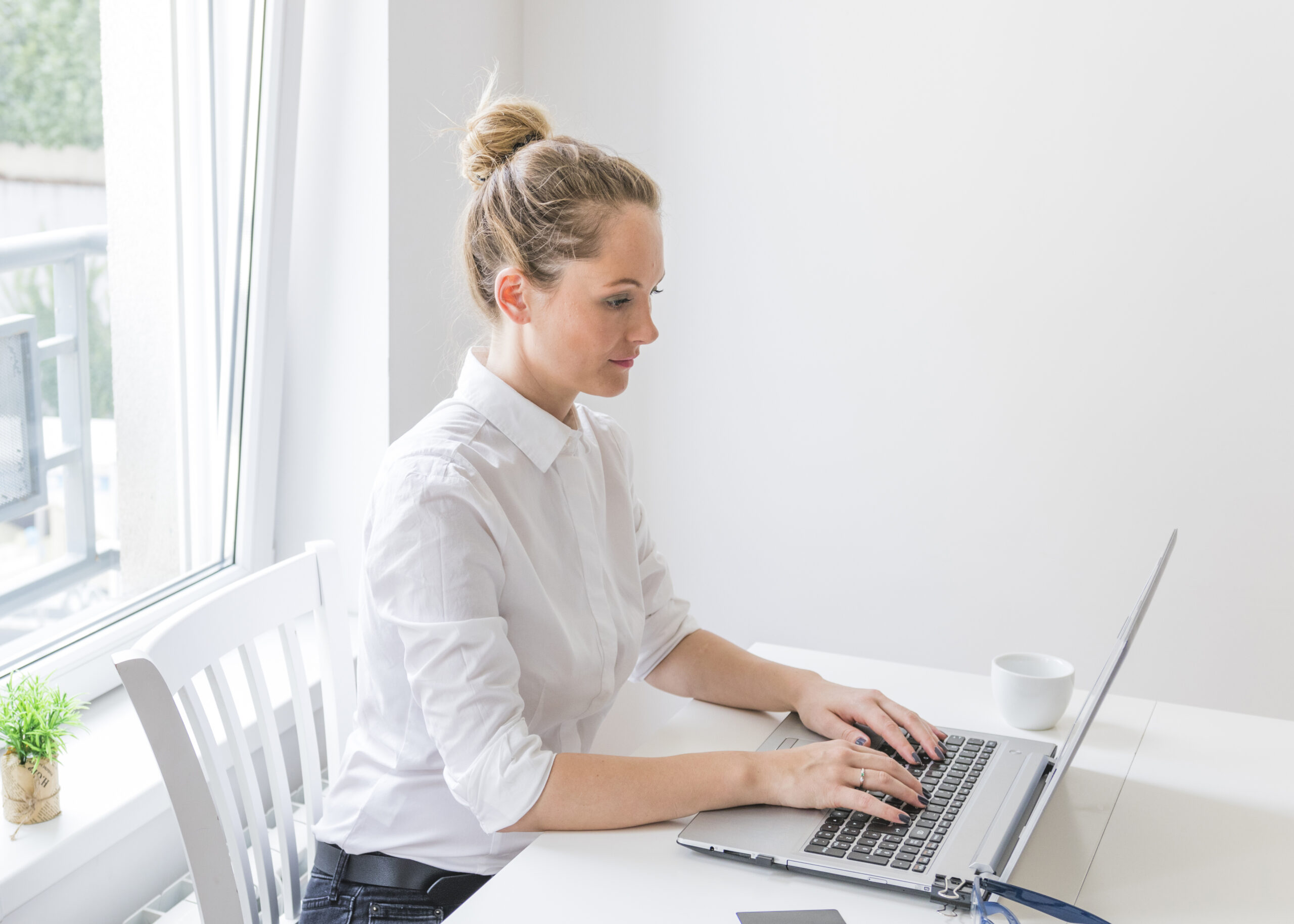 side-view-of-confident-young-woman-using-laptop